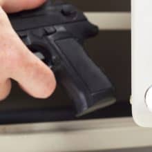 Person putting firearm in gun safe